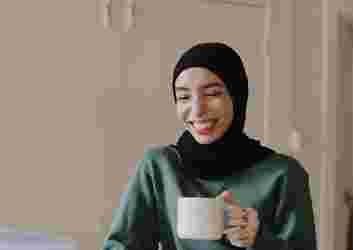 woman drinking coffee on laptop