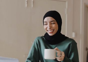 woman drinking coffee on laptop