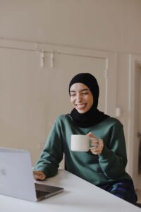 woman drinking coffee on laptop