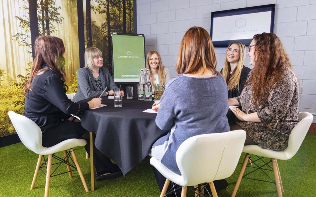 women at business meeting room with forest decor at yarnfield park
