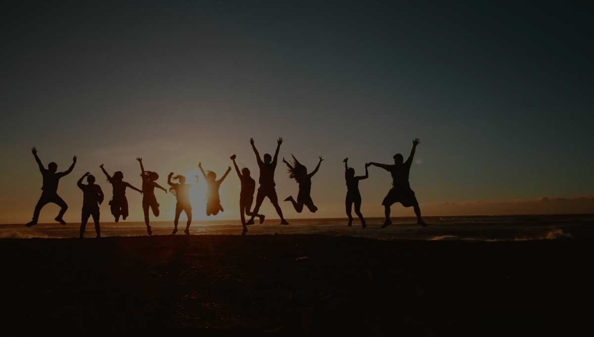 silhouette of people jumping at sunset