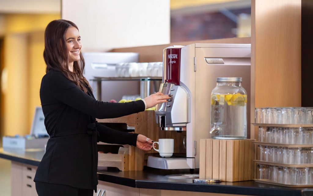 woman pouring a coffee at yarnfield park drinks station