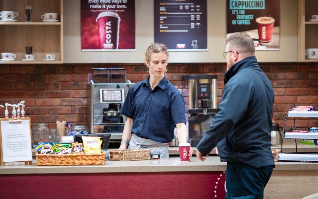 staff and customer at costa cafe