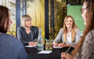 women at business meeting room with forest decor at yarnfield park