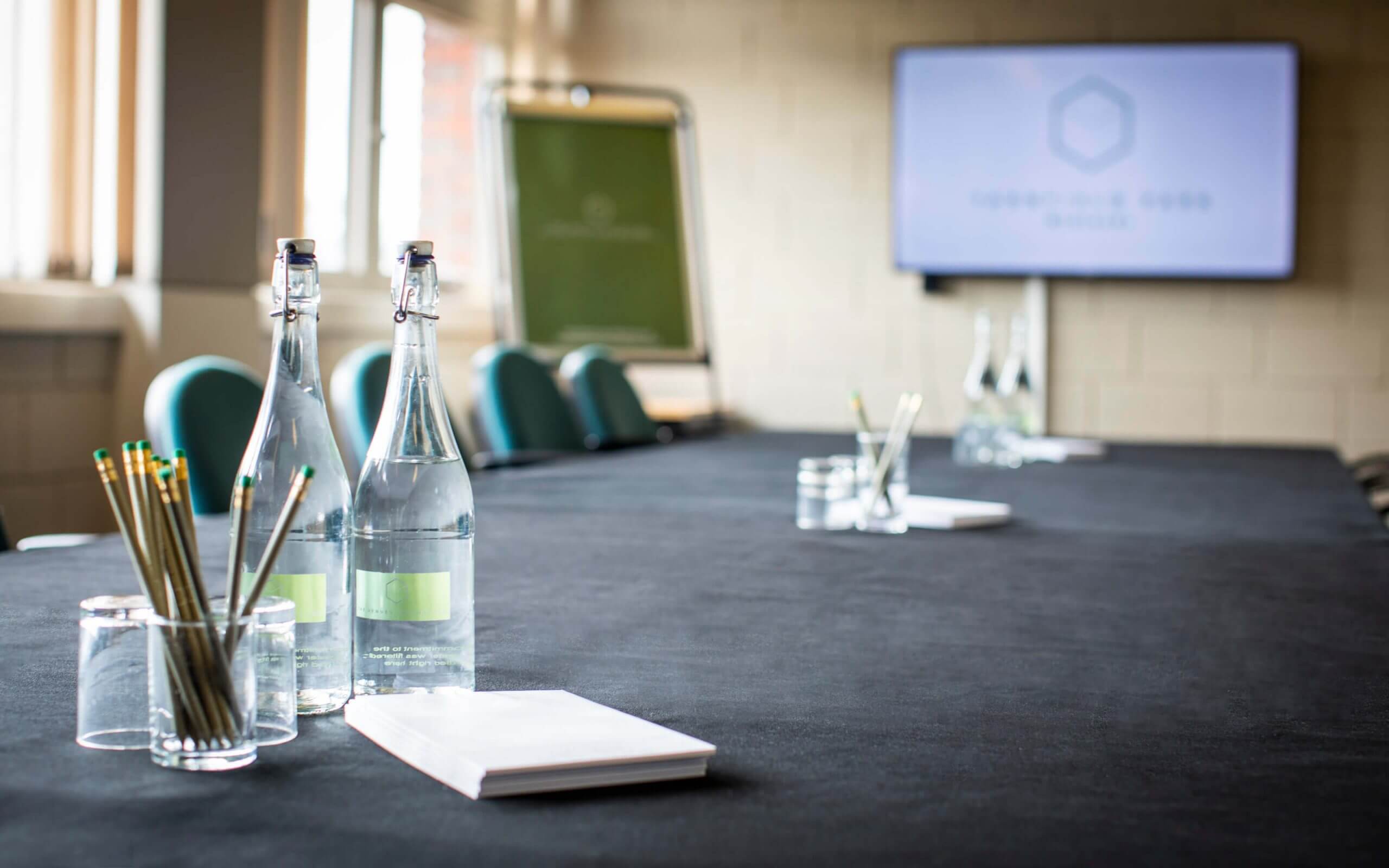 water bottles and stationary on meeting room table