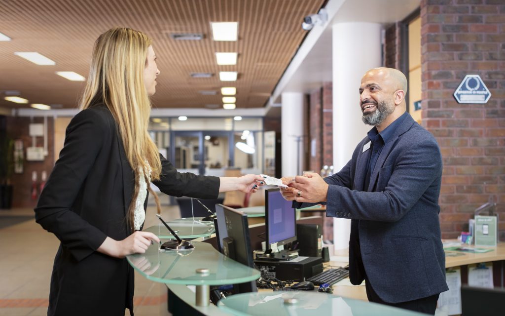 man and woman at hotel reception desk