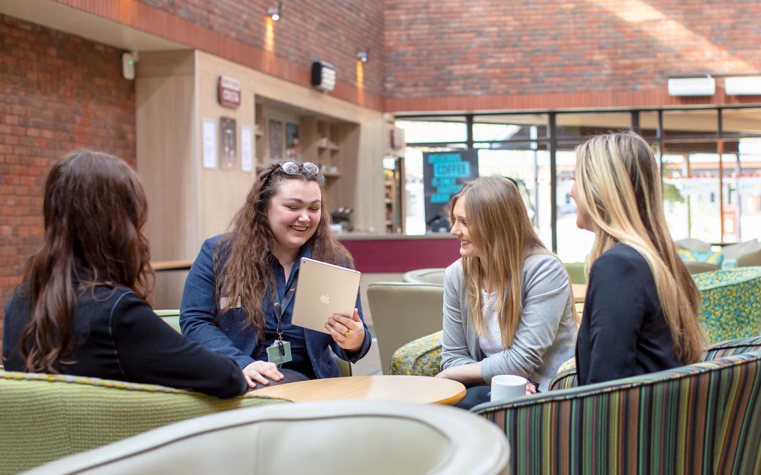 professional group of women sat at table in yarnfield park atrium